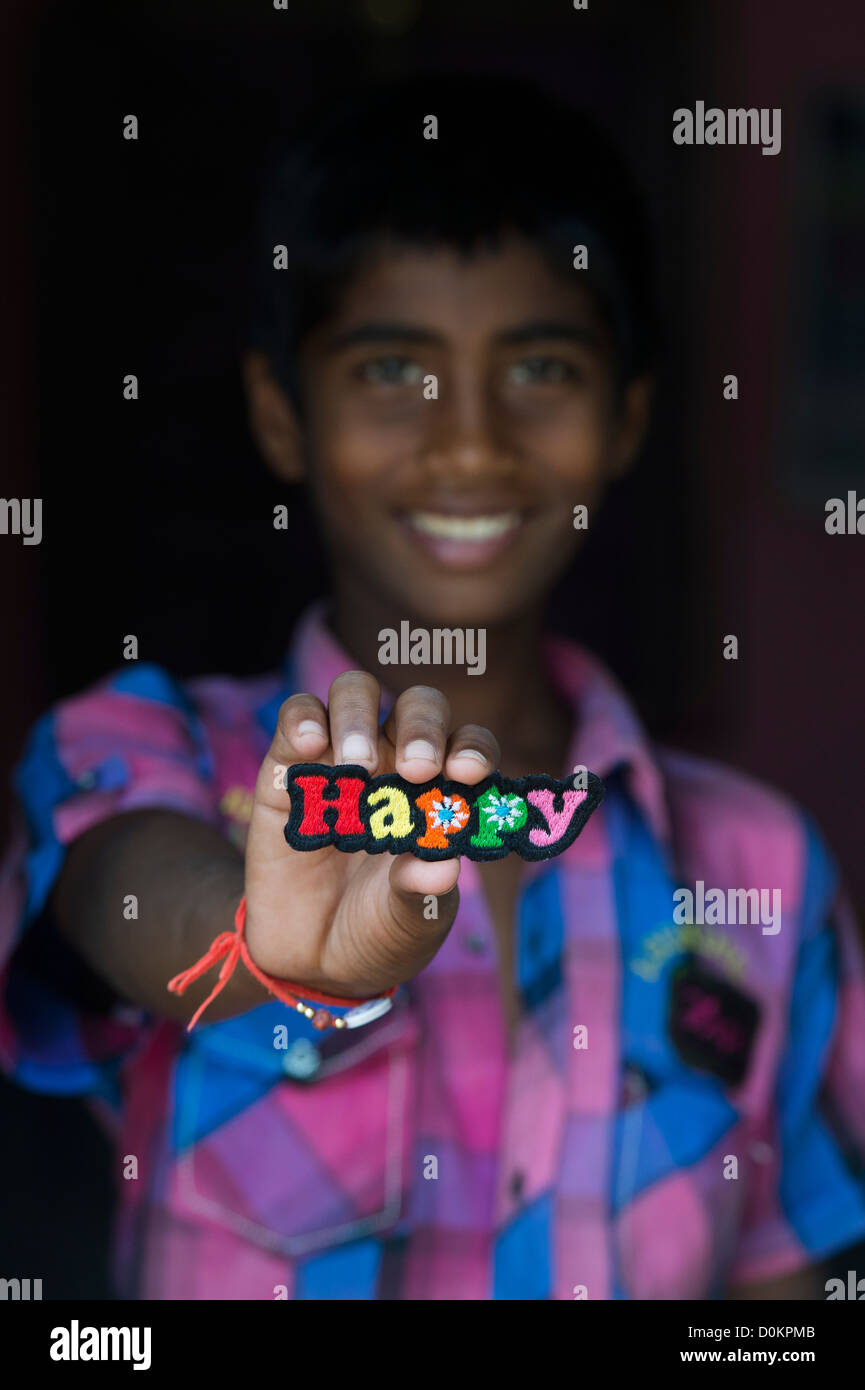 Smiling Indian boy holding a HAPPY multicoloured embroidery patch Stock Photo