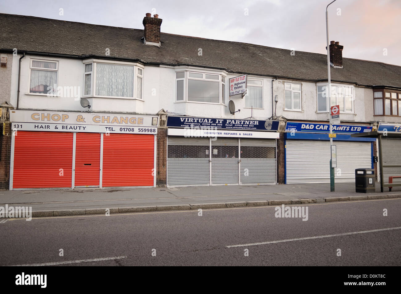 A row of closed shops with their shutters down in Rainham. Stock Photo