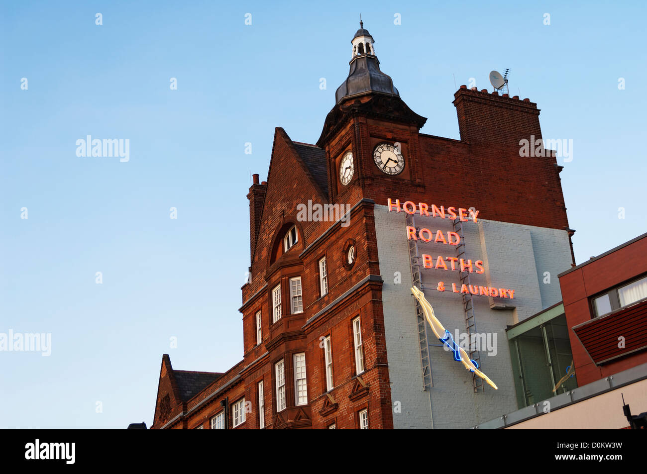 Looking up at a neon sign for the Hornsey Road Baths and Laundry. Stock Photo