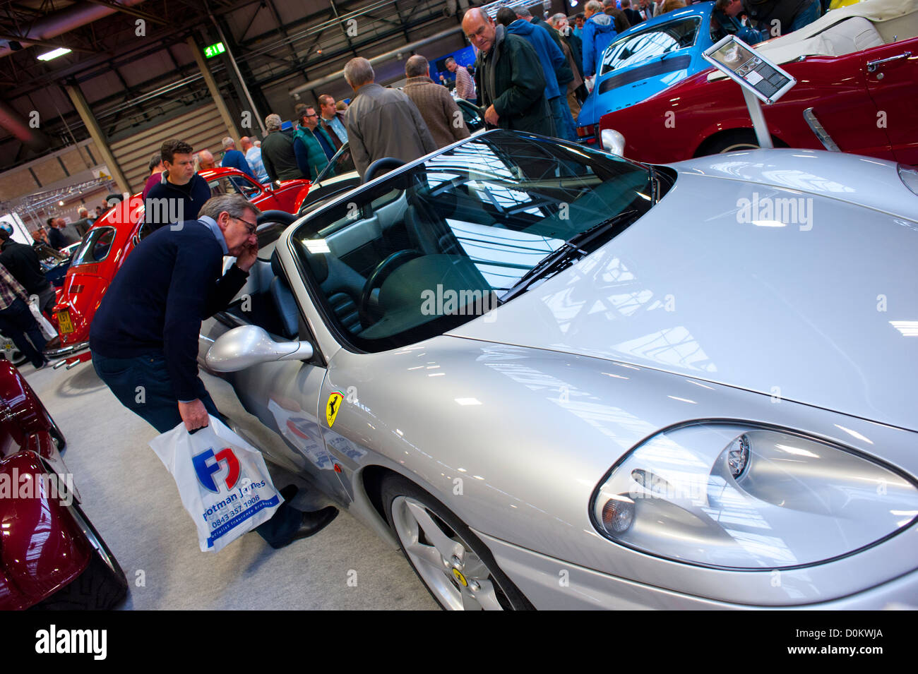 Enthusiast inspects a Ferrari sports car at the 2012 Classic Motor Show