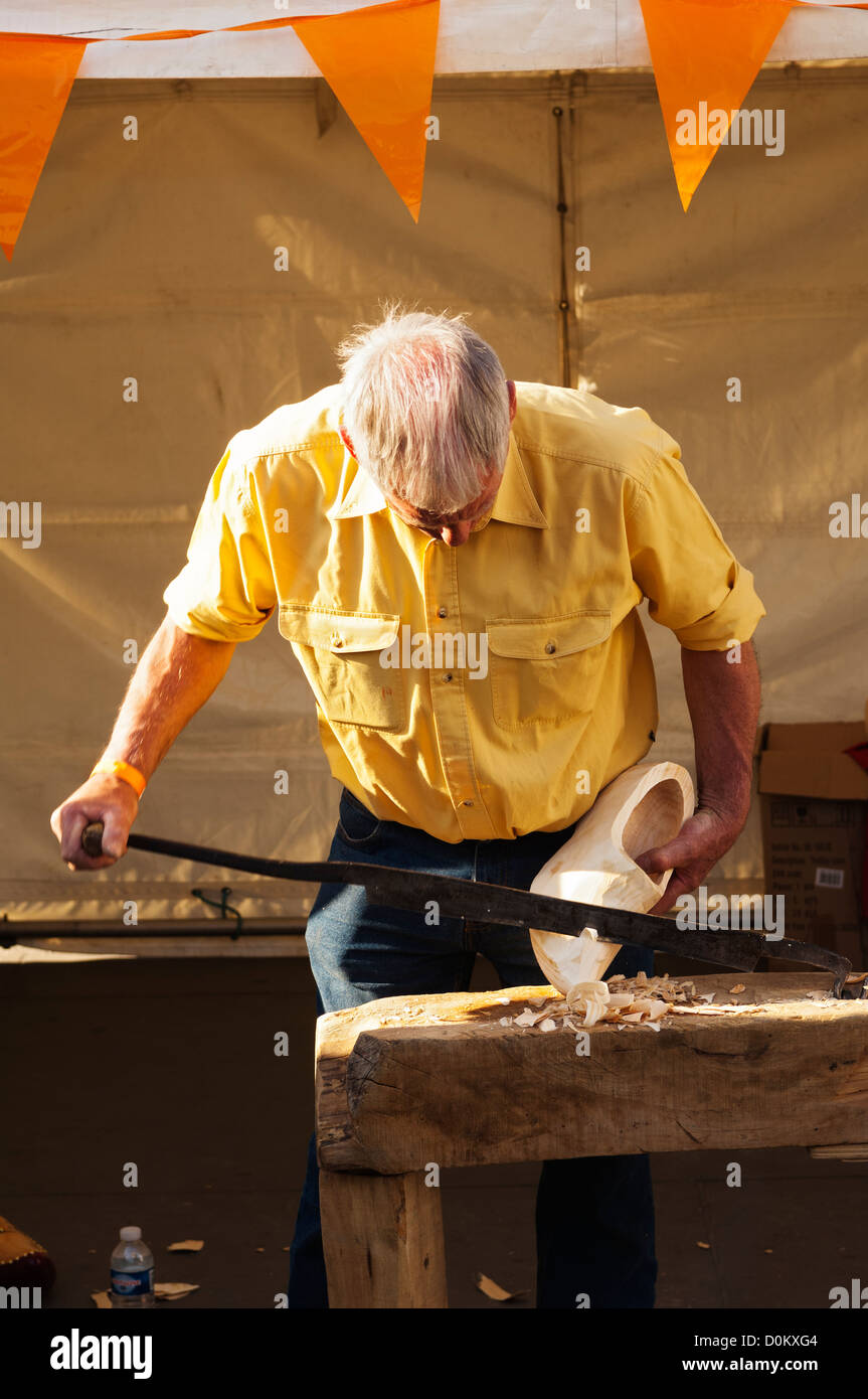 A man showing how they make hand-carved wooden clogs in Trafalgar Square as part of a celebration of Dutch culture during the Ho Stock Photo