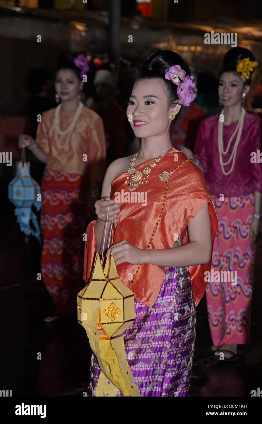 Thai ladies carry lanterns in a parade in Chiang Mai to mark Loy Krathong. The festival is a time to rid oneself of worries by floating them away on a krathong,a small banana leaf boat. Stock Photo