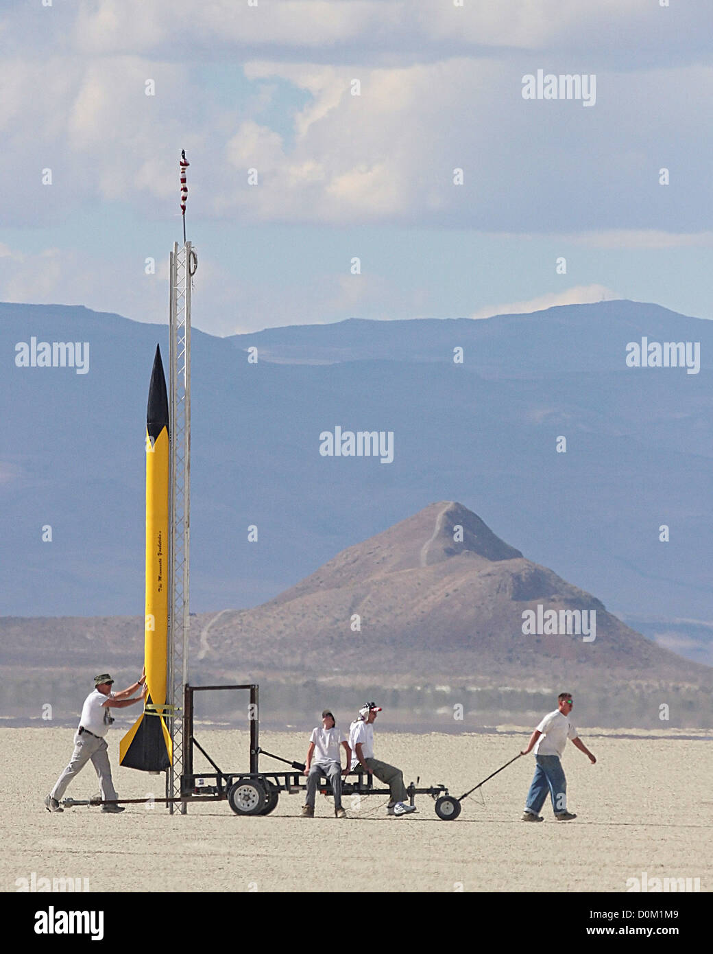 A small group people pull yellow rocket 'The Minnesota Youbetcha' out