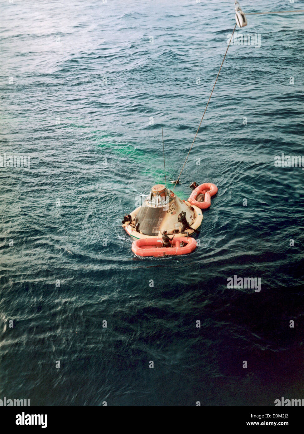 The Apollo Spacecraft 009 command module as frogman team prepares it be ...