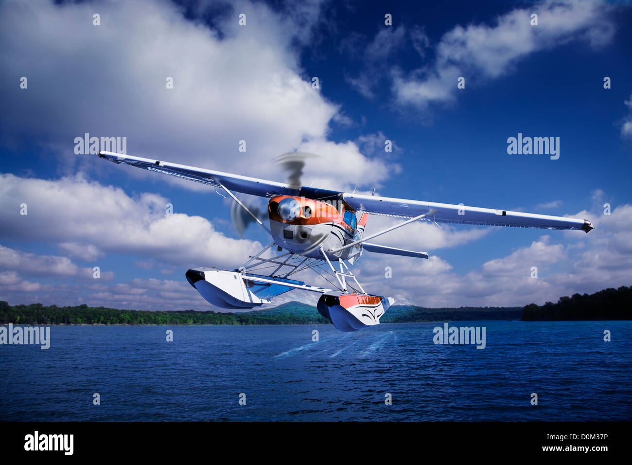 A Cessna 206 with floats takes off from a lake. Stock Photo
