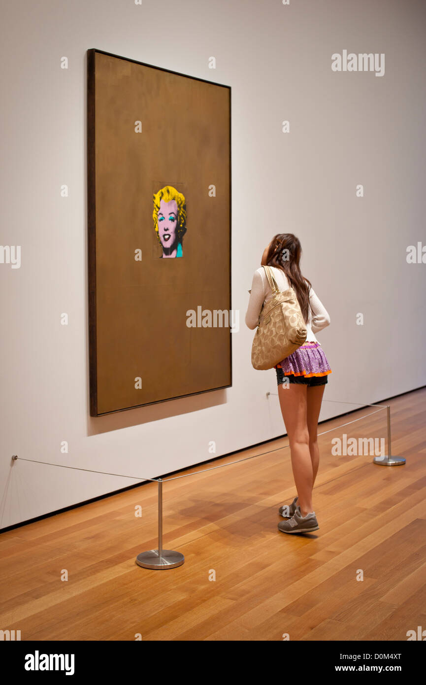 A young Asian woman looks closely at Warhol's Marilyn, MOMA,NY Stock Photo