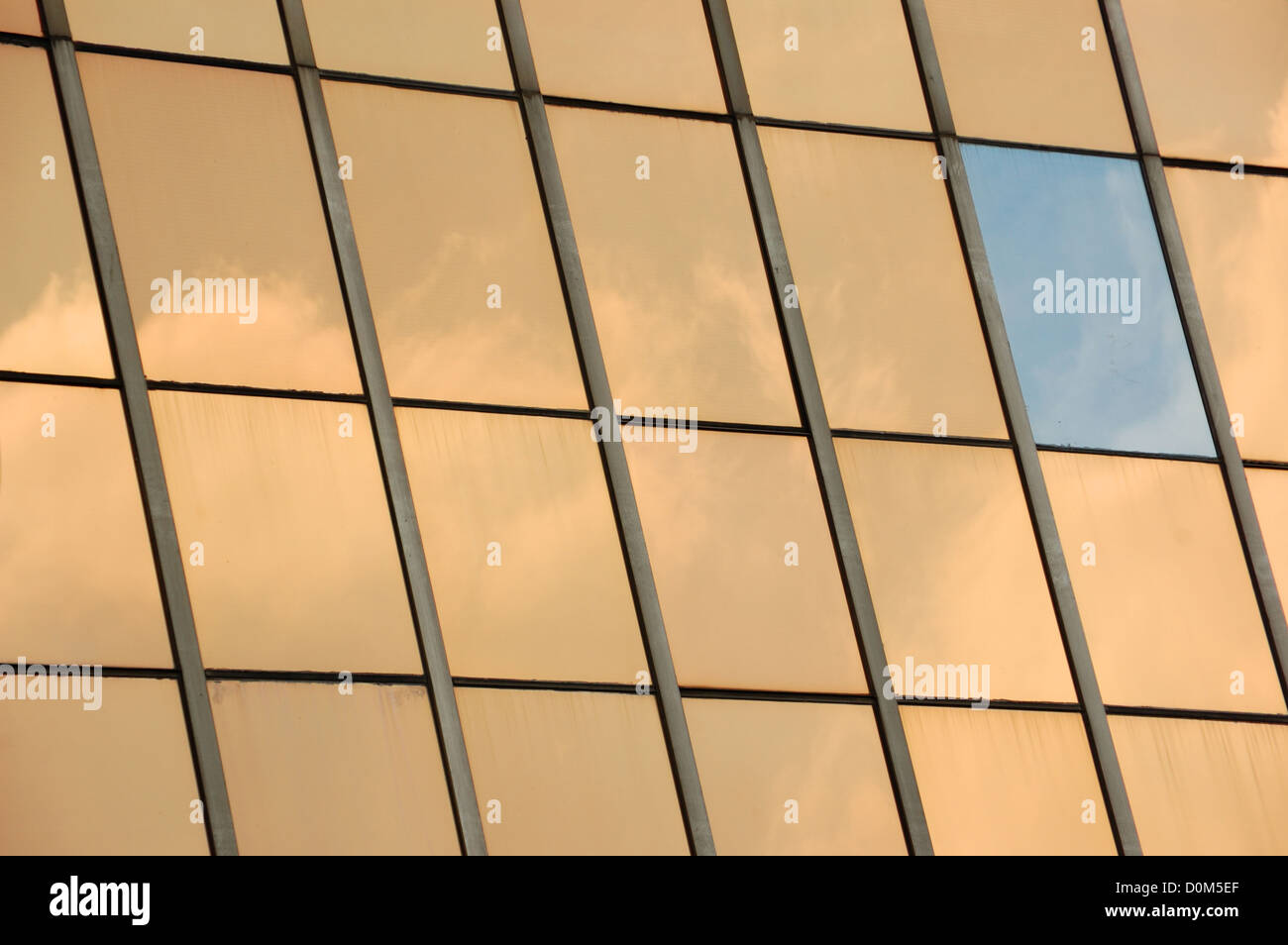 Sky reflected on glass facade panel of a modern building. Abstract background. Stock Photo