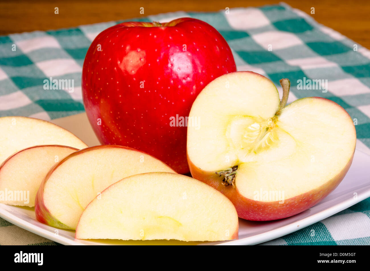 Fresh red apple sliced on a white plate Stock Photo