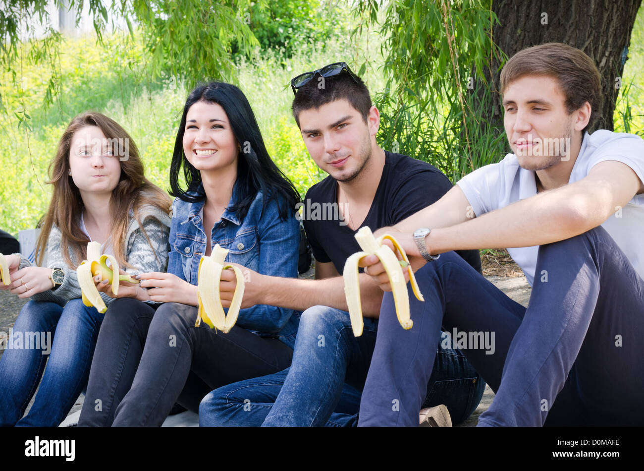 Row of young college friends sitting together watching an event with focus to the middle couple Stock Photo