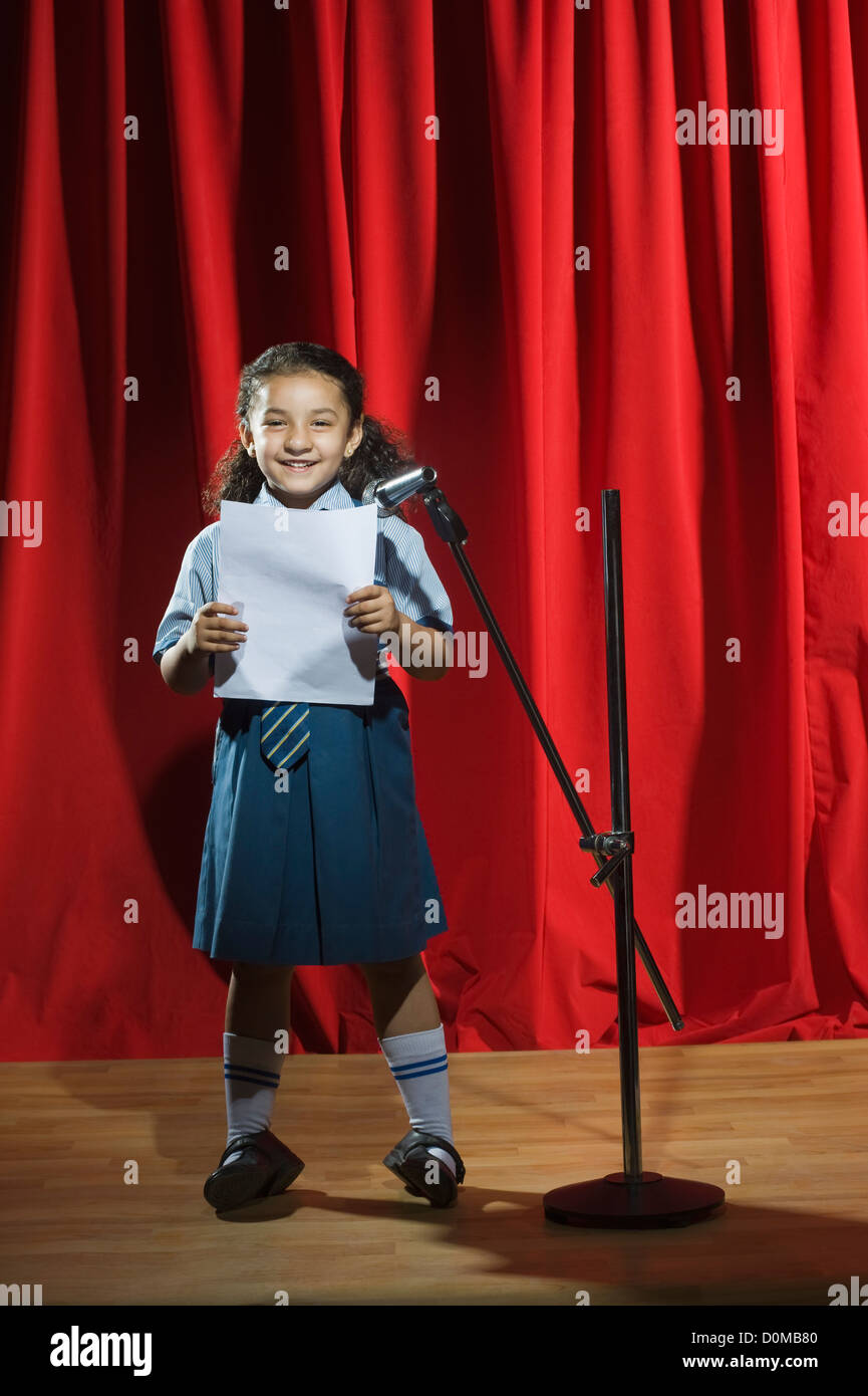 Schoolgirl giving speech on a stage Stock Photo