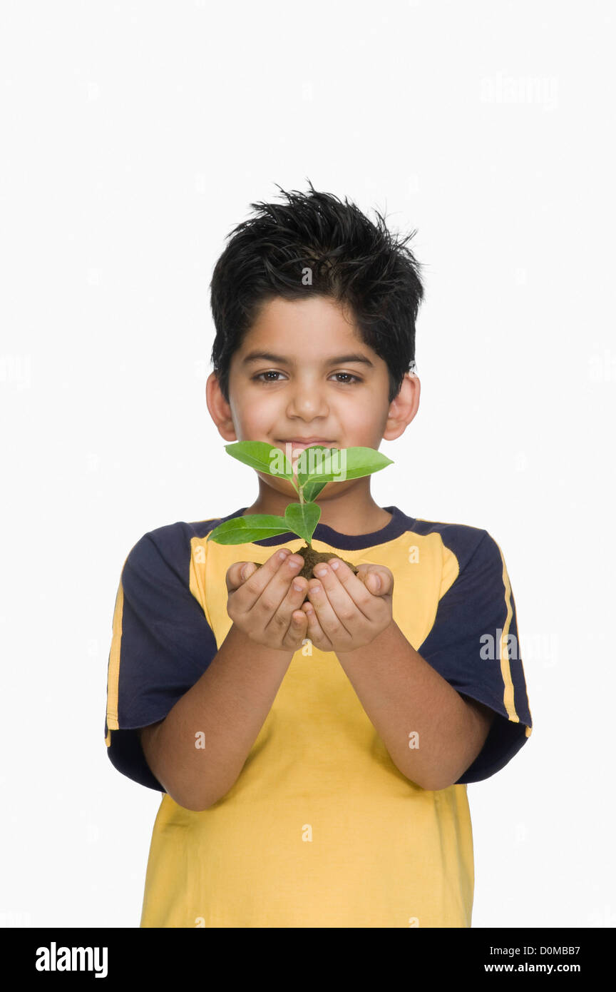 Portrait of a boy holding a plant Stock Photo - Alamy