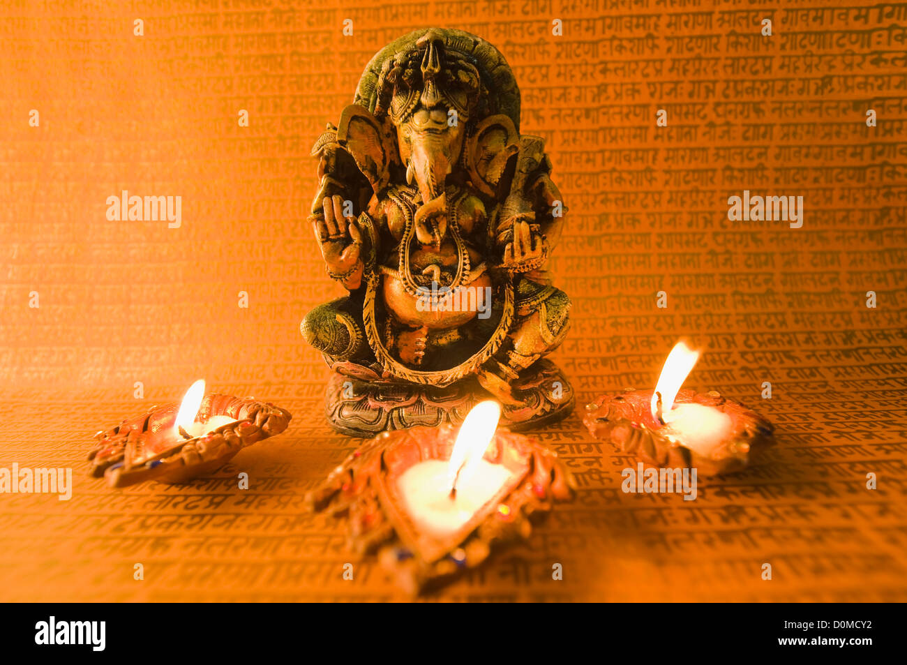 Diwali oil lamps in front of an idol of Lord Ganesha Stock Photo