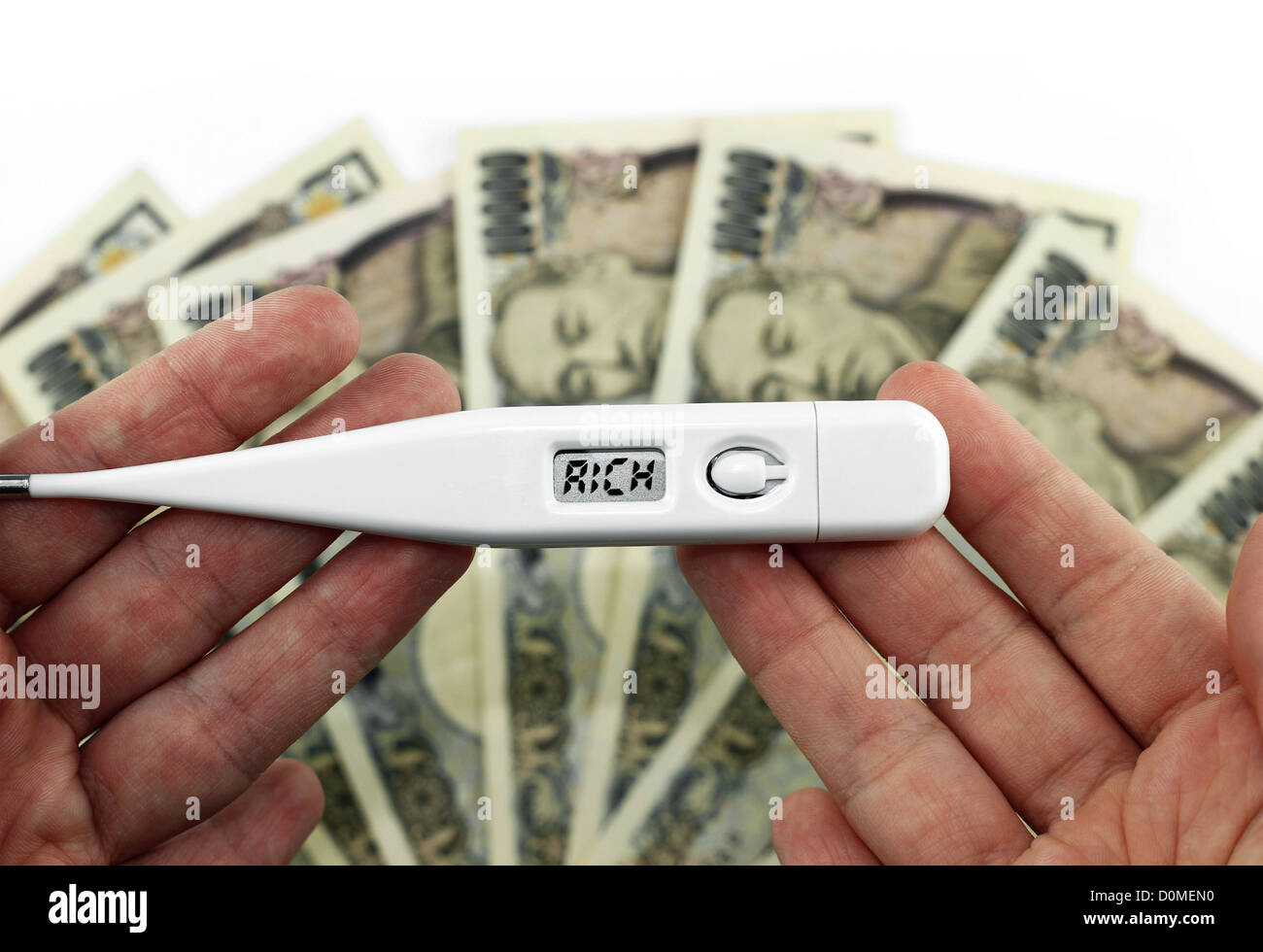 Money concept: hand holding thermometer that shows rich instead of temperature, with money in the background Stock Photo