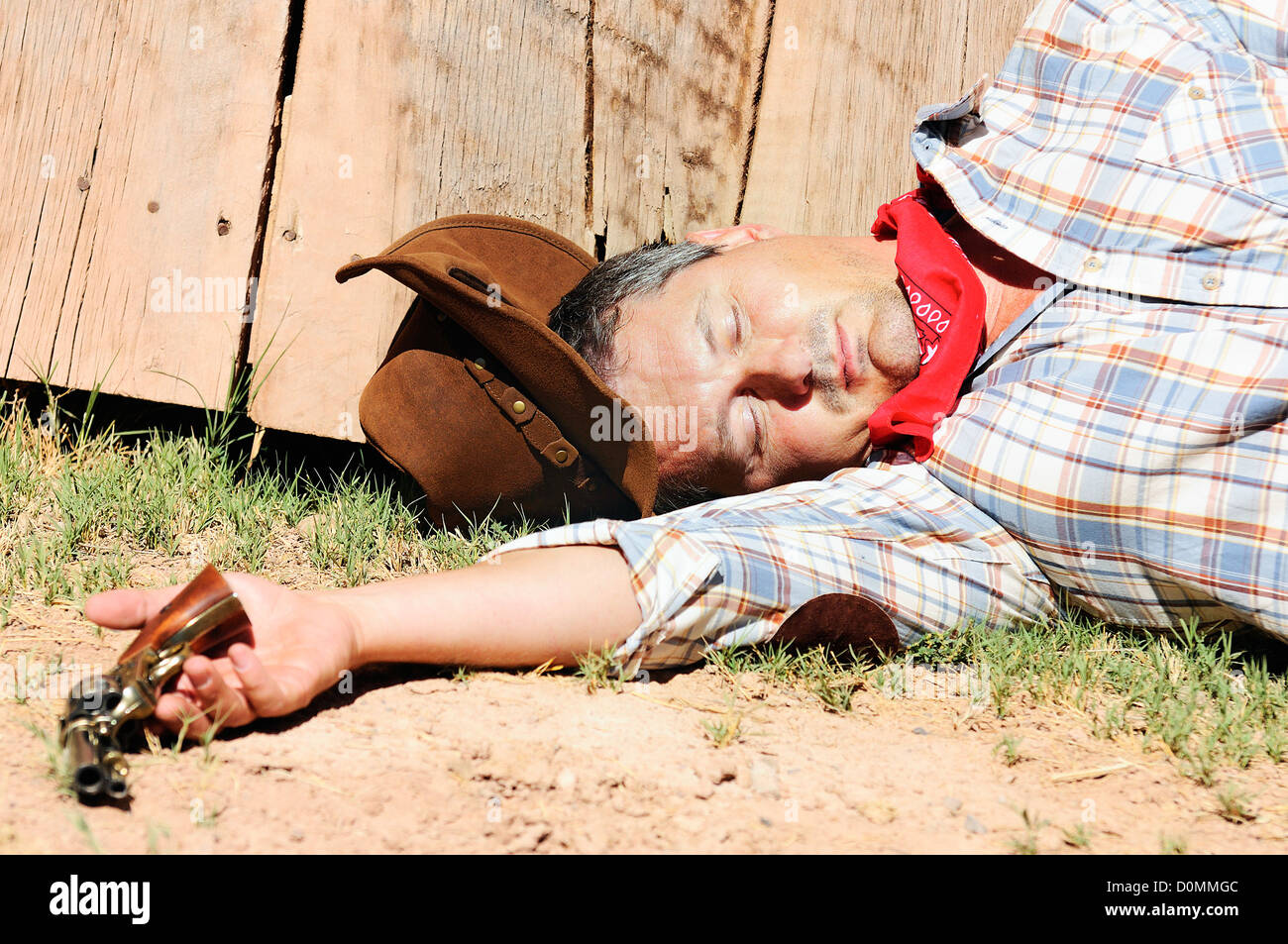 OUT WEST - A cowboy dead with arm in his hand Stock Photo