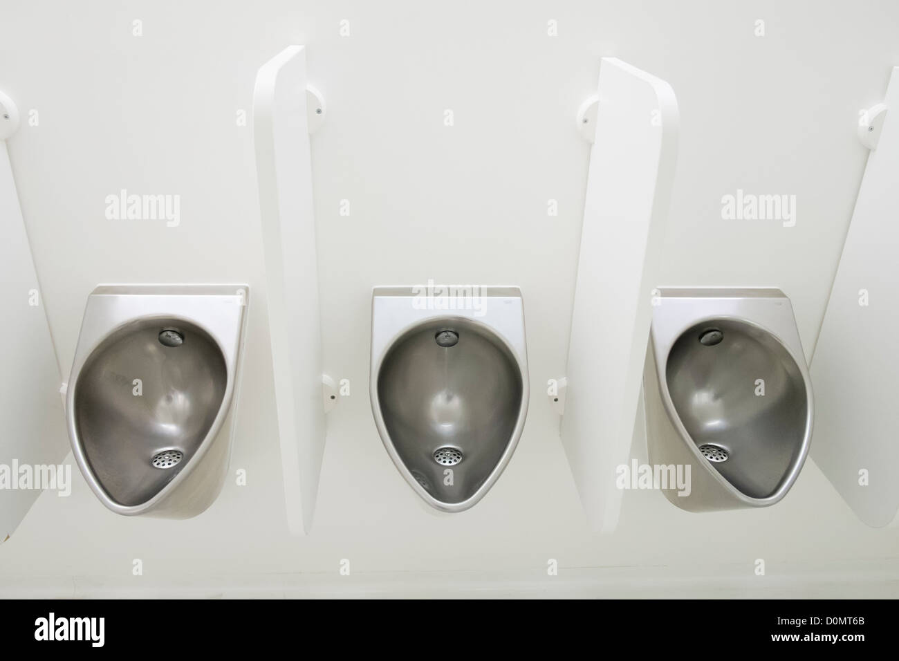 Modern stainless steel urinals in mens lavatory Stock Photo