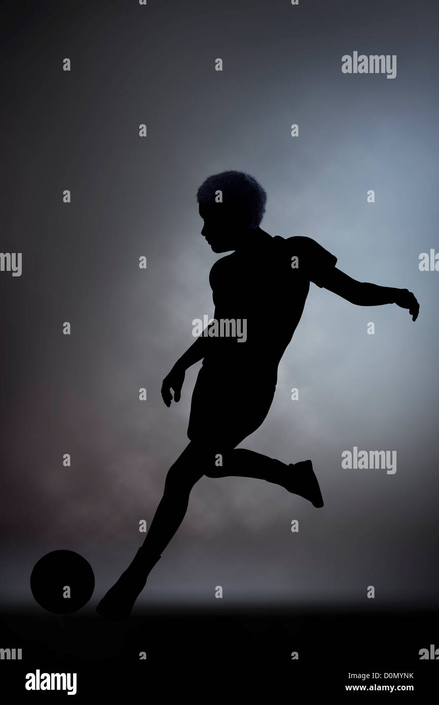 Silhouette Of A Boy Kicking A Soccer Ball Stock Photo Alamy