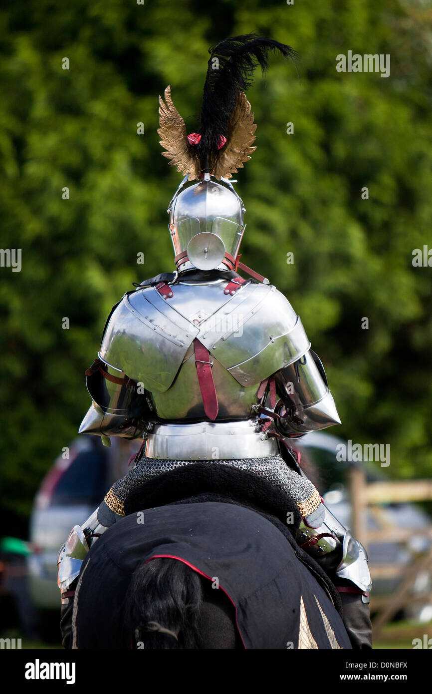 Knight in shining armour riding black horse Stock Photo Alamy