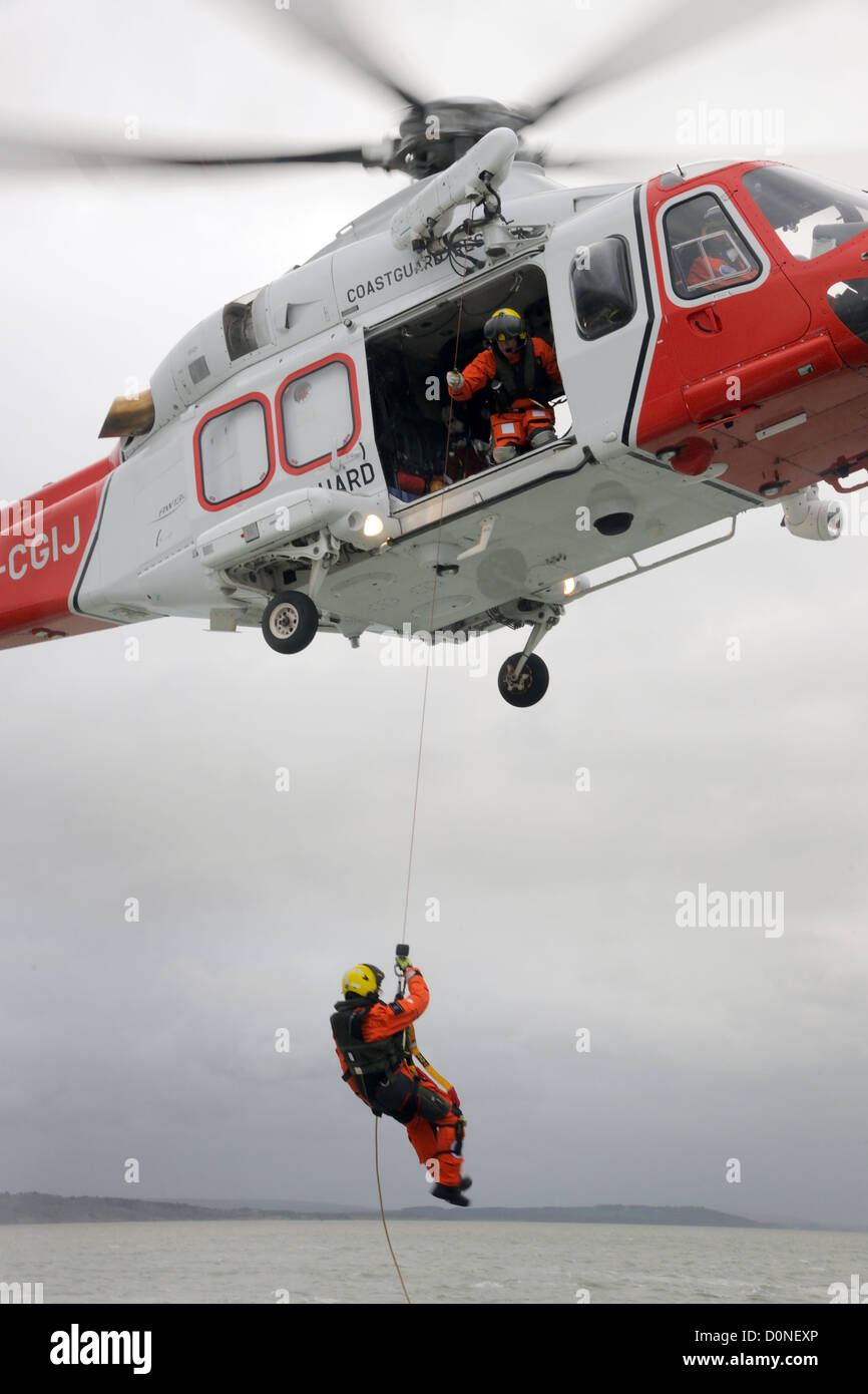 Coastguard rescue helicopter lowers a crewman Stock Photo