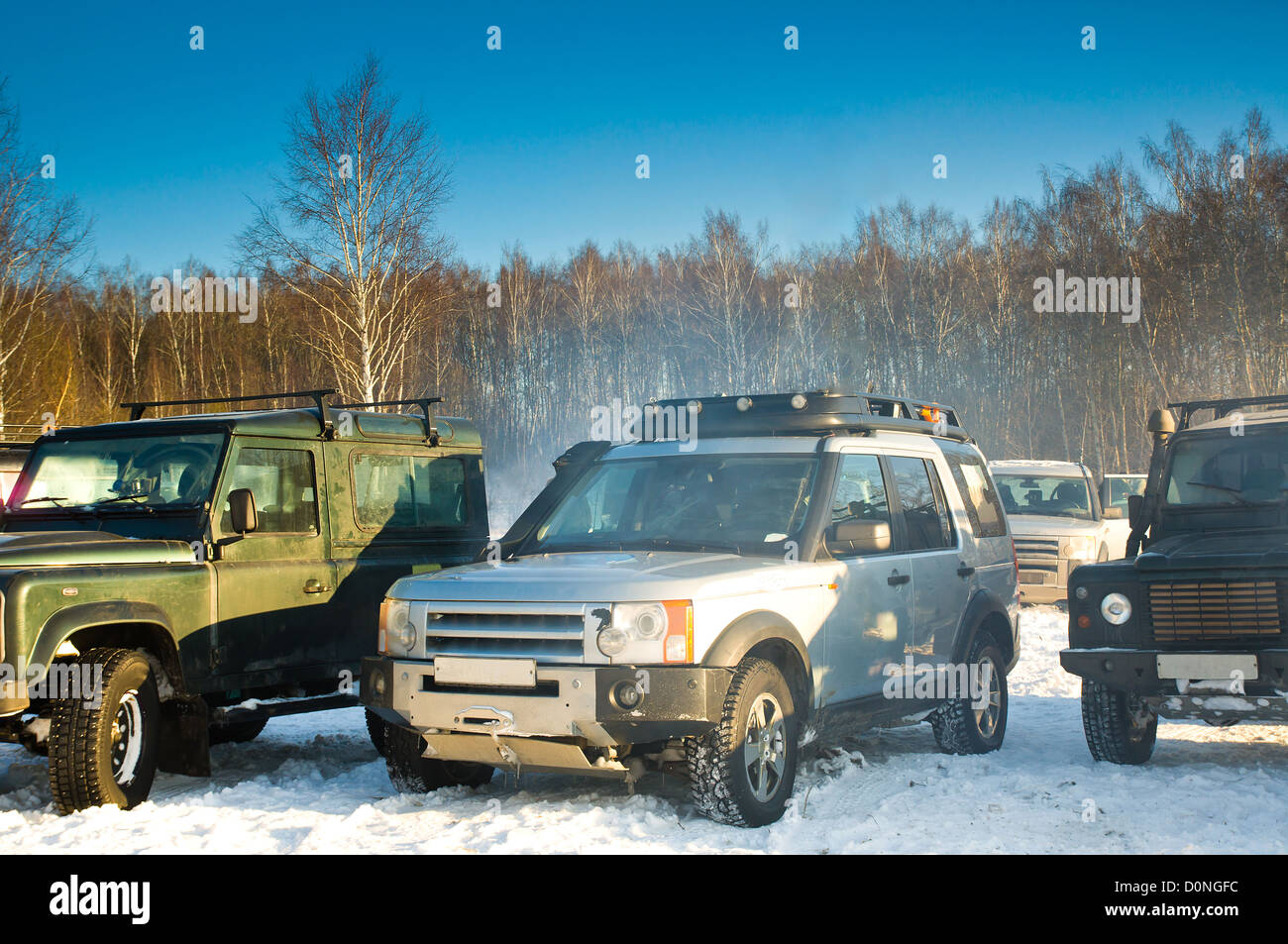 Land Rover Discovery and two Defender. Three SUV on background the Russian winter. Stock Photo