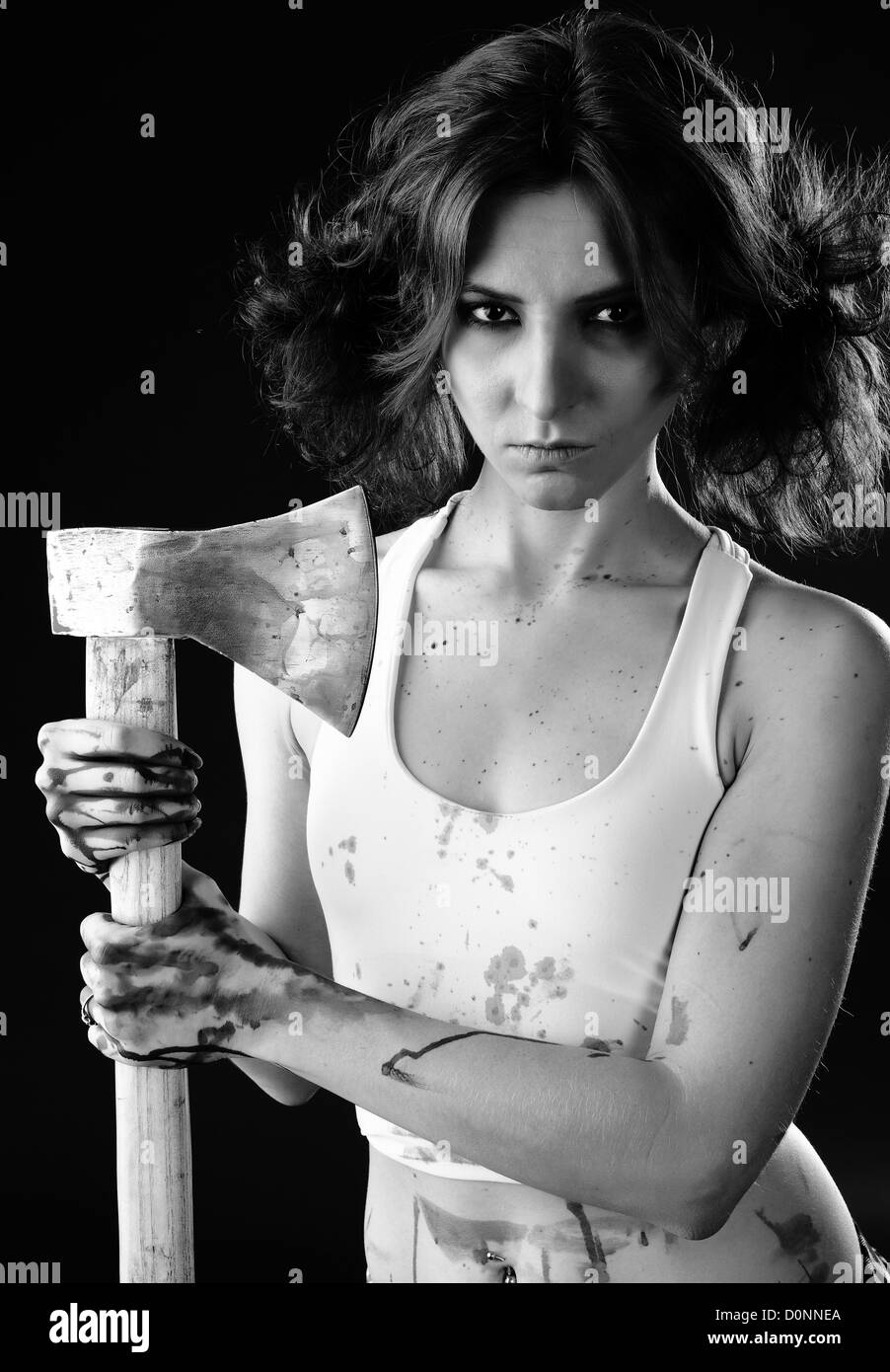 studio shot on black background: young woman holding bloody axe (axe girl) Stock Photo