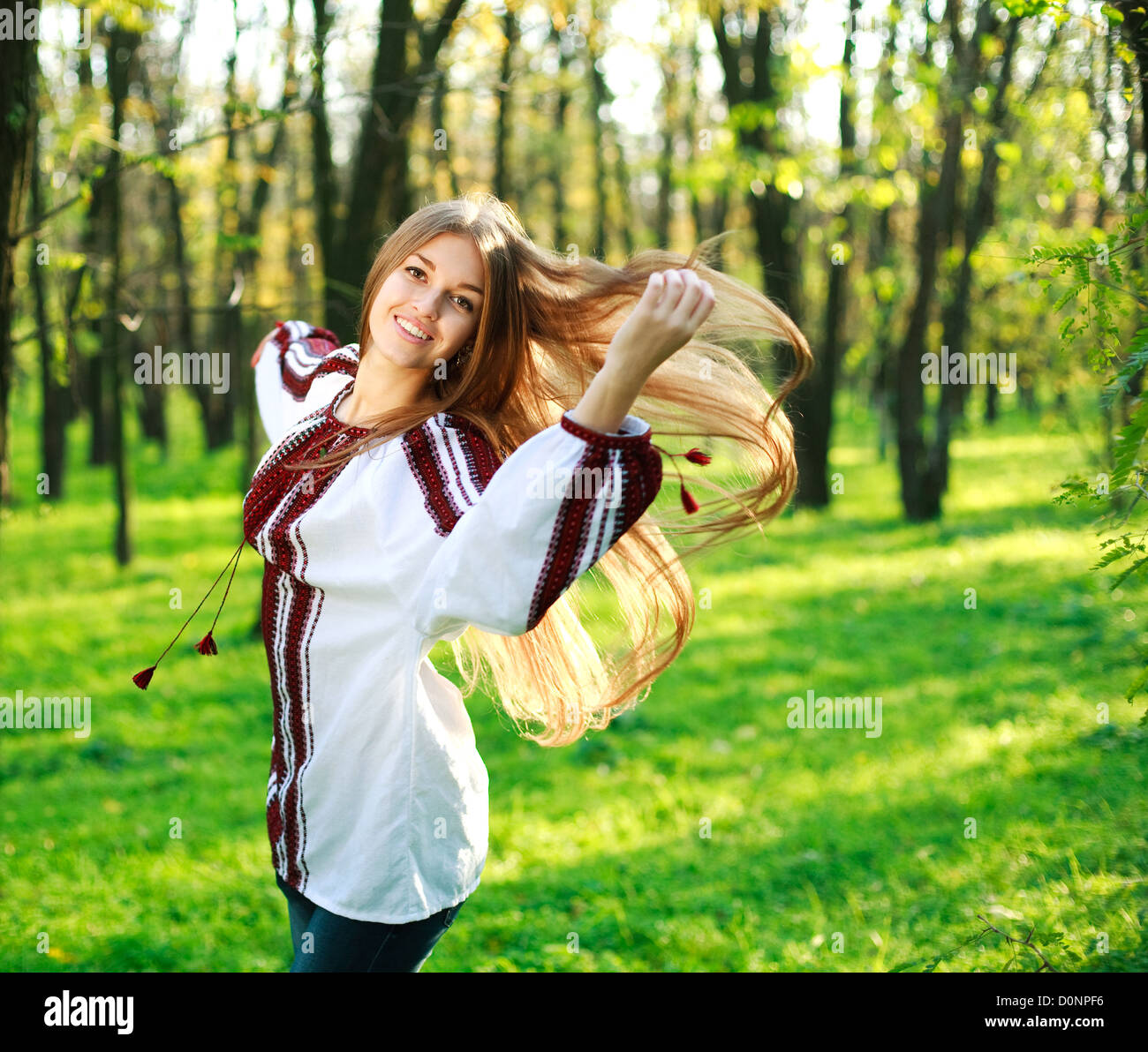 Smiling Cute Girl With Long Hair Dancing In Green Park Stock Photo