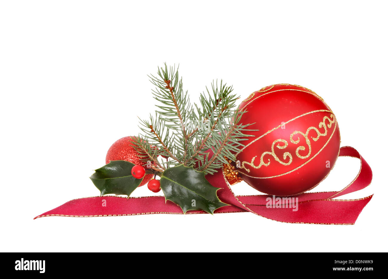 Christmas decoration, red and gold baubles with holly fir tree foliage and red ribbon isolated against white Stock Photo