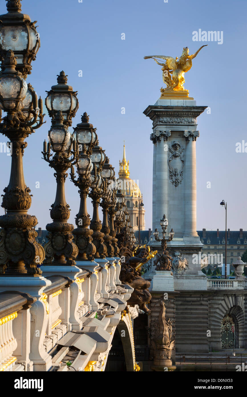 Ornate lamps along Pont Alexandre III with the dome of Hotel des Invalides beyond, Paris France Stock Photo