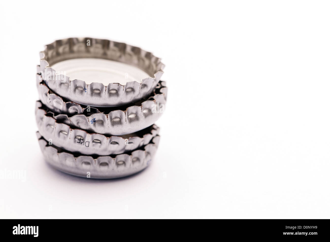 Stacked white and silver metal bottle tops Stock Photo