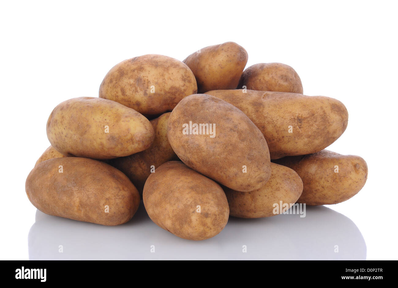 Closeup of a pile of russet potatoes on a white surface with reflection. Horizontal format. Stock Photo