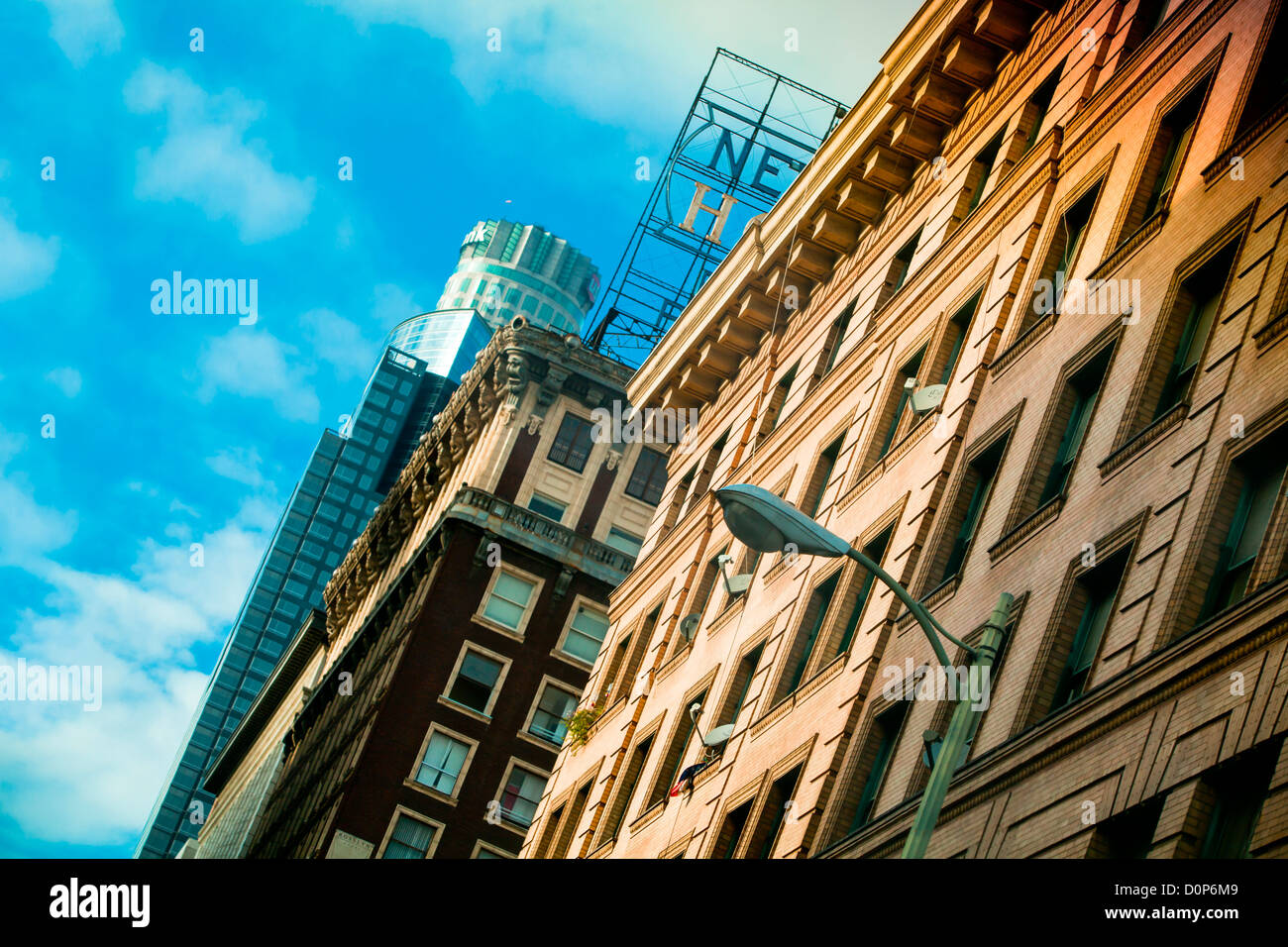 Old and sky scraper buildings in Downtown Los Angeles below a blue sky street lamp Stock Photo