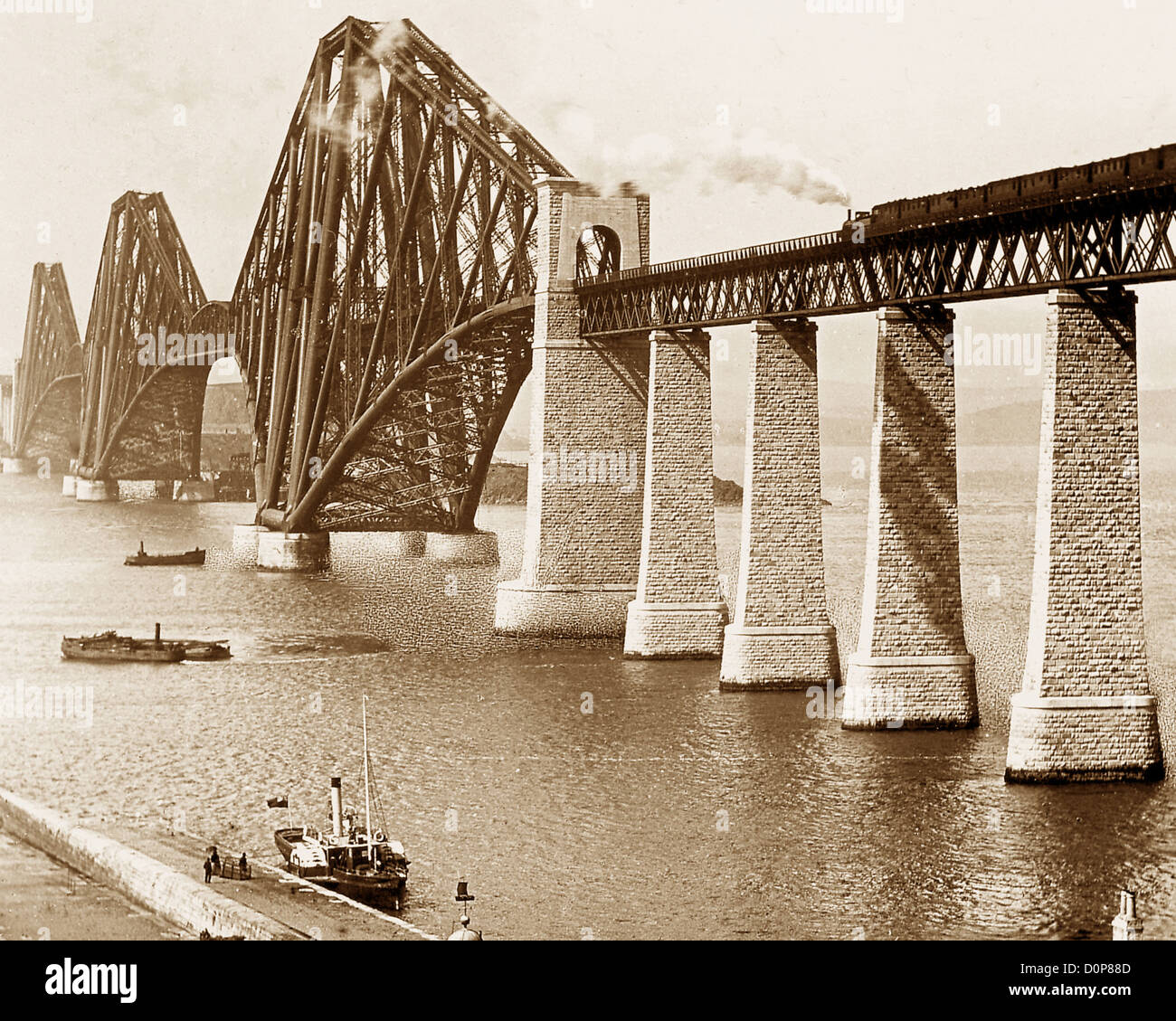 The Forth Railway Bridge with ferry and steam train late Victorian period Stock Photo