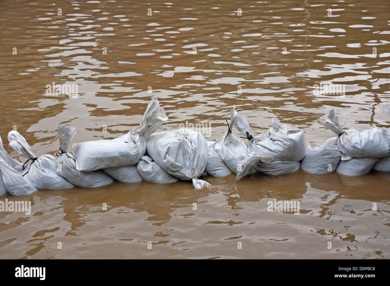 useless wall of sandbags to fend off raging river Stock Photo