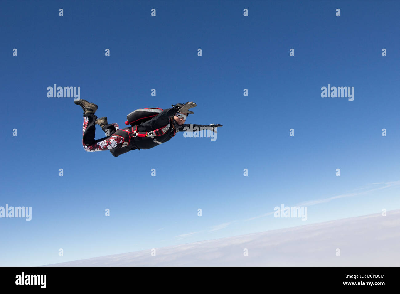 Senior Skydiver is falling through the blue sky with over 120mph. He started this sport to feel younger as a pensioner. Stock Photo