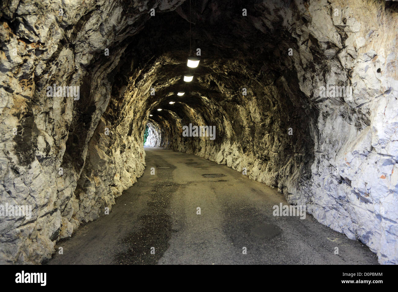 Narrow illuminated tunnel in a rock Stock Photo