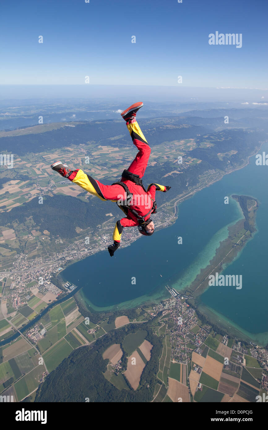 Skydiver tracking in head low position over a nice lake area. It is fun to fly fast with a speed of 125mph through the sky. Stock Photo