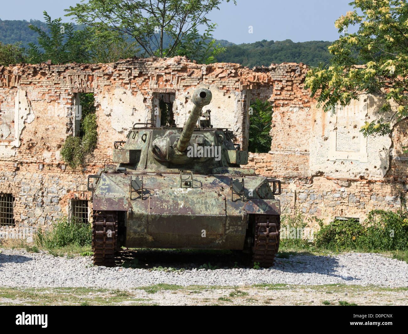 old army tank infront of burned house Stock Photo