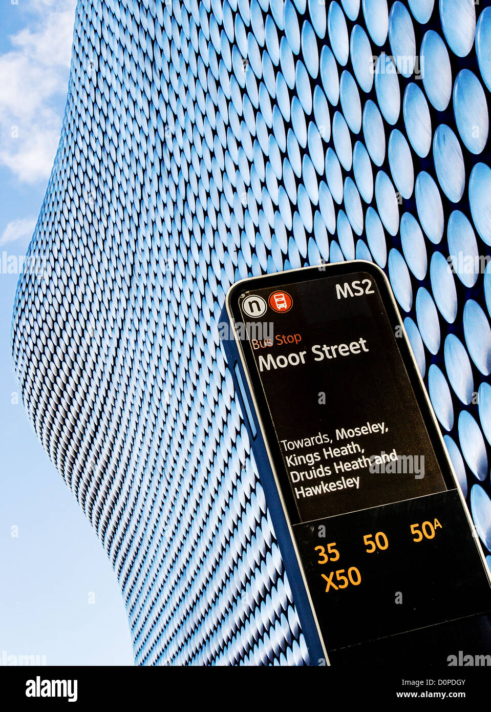 Bus stop sign at Moor Street in Birmingham UK against the sinuous exterior of