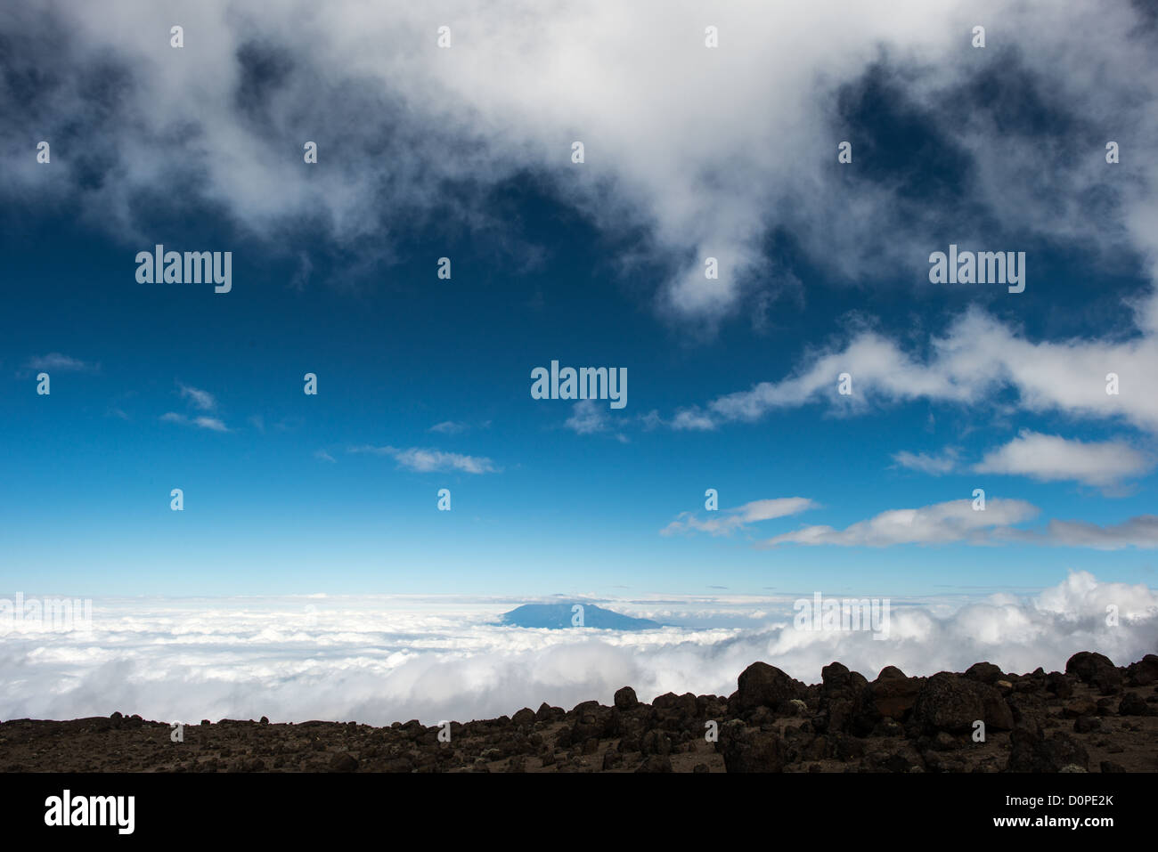 MOUNT KILIMANJARO, Tanzania — The summit of Mt Meru pokes through the clouds, as seen from about 14,500 feet on Mt Kilimanjaro's Lemosho Route. Stock Photo