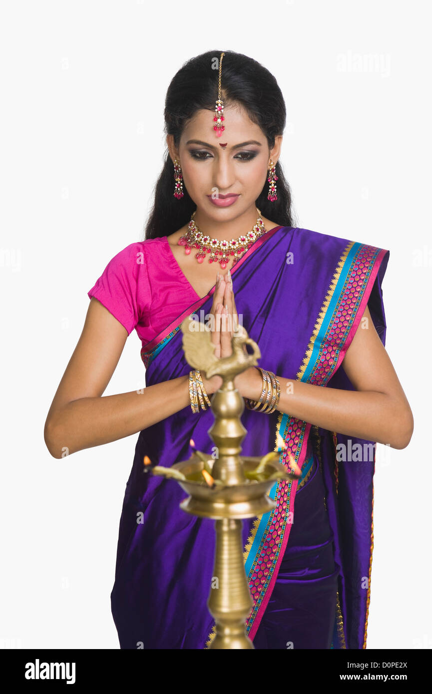 Woman praying with oil lamp in front of her Stock Photo Alamy