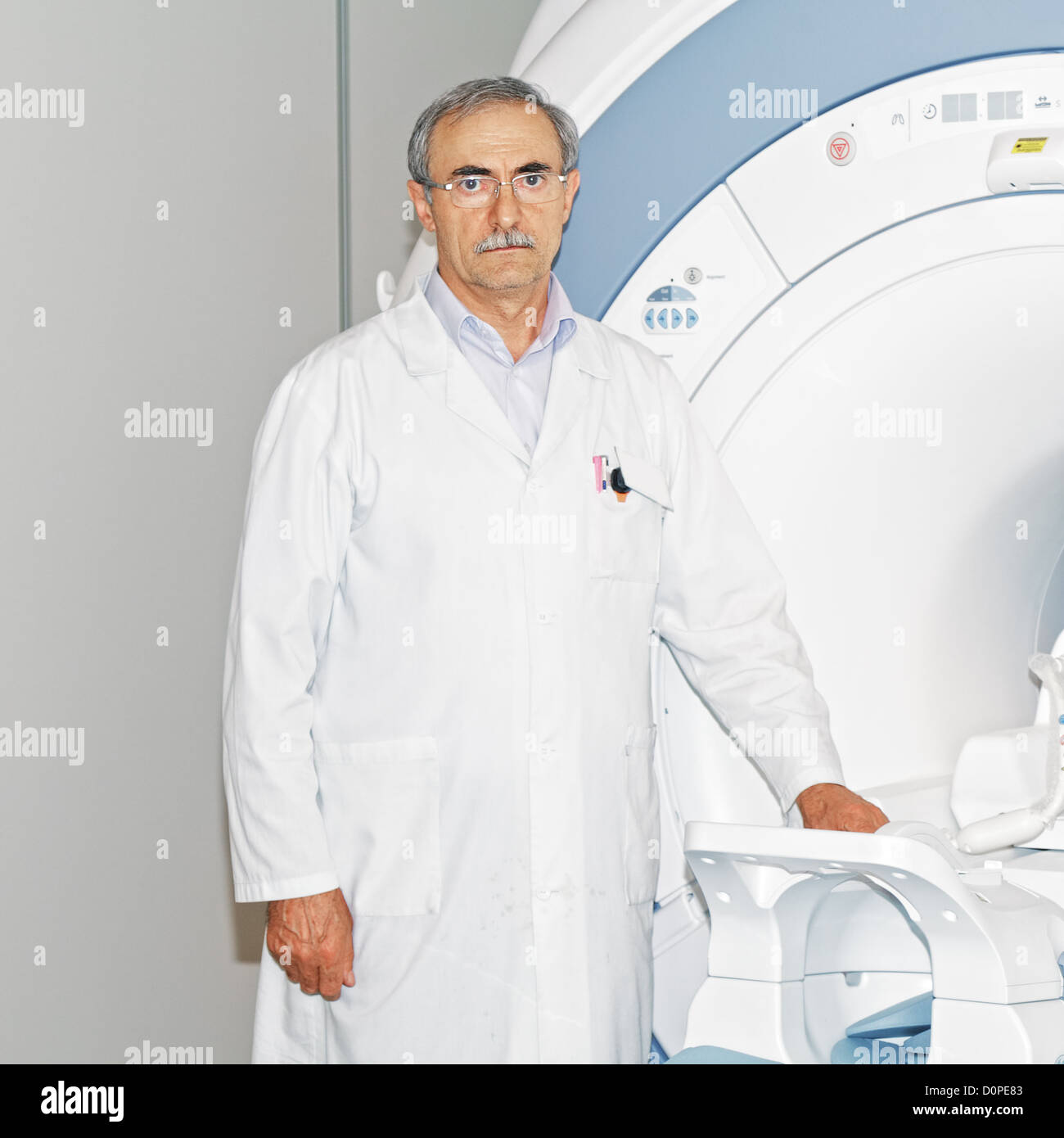 Doctor standing at tomograph Stock Photo