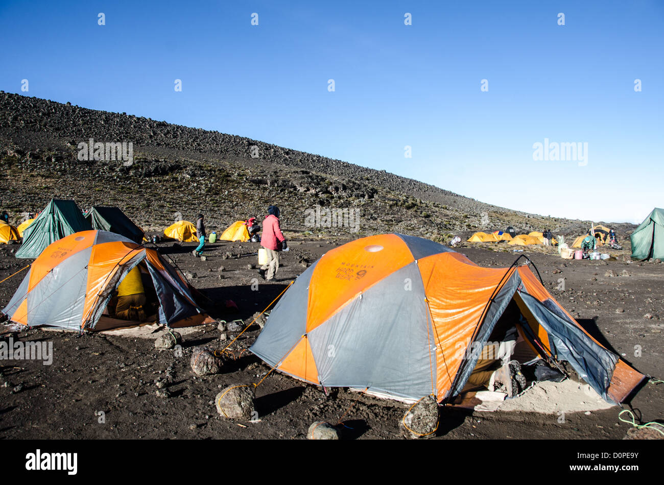 MOUNT KILIMANJARO, Tanzania — Tents are positioned at Moir Hut Camp, situated at 13,660 feet elevation on Mount Kilimanjaro's Lemosho Route. The camp serves as one of the designated stopping points for climbers ascending Africa's highest peak via the Lemosho approach. Mount Kilimanjaro, located in northern Tanzania near the Kenyan border, rises to 19,341 feet and attracts thousands of trekkers annually. The Lemosho Route is widely considered one of the more scenic approaches to the summit, typically taking seven to eight days to complete. Moir Hut Camp provides a crucial acclimatization stop f Stock Photo