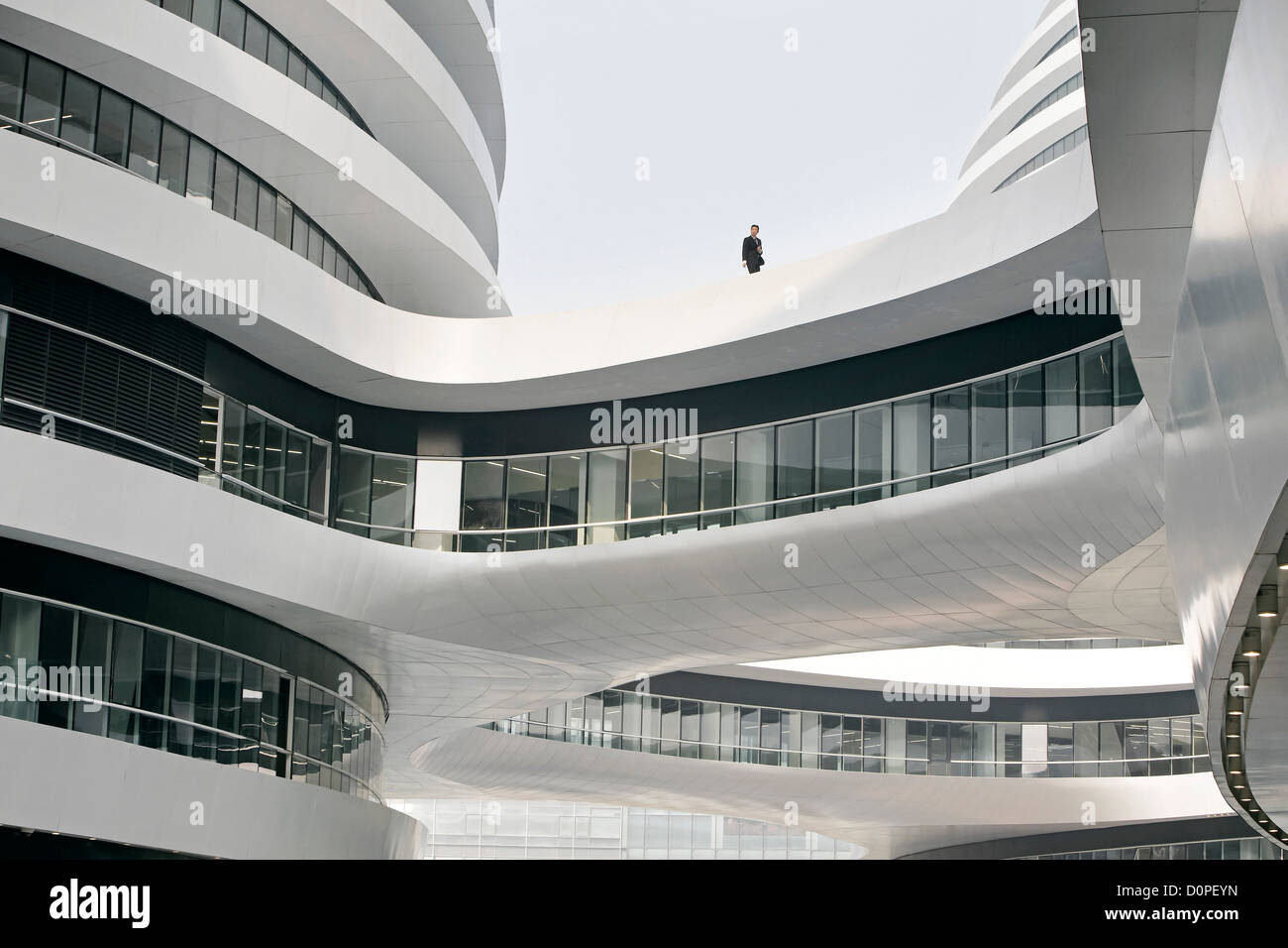 Galaxy Soho, Beijing, China. Architect: Zaha Hadid Architects, 2012. Detailed view upwards with bridge link and glass curtain wa Stock Photo