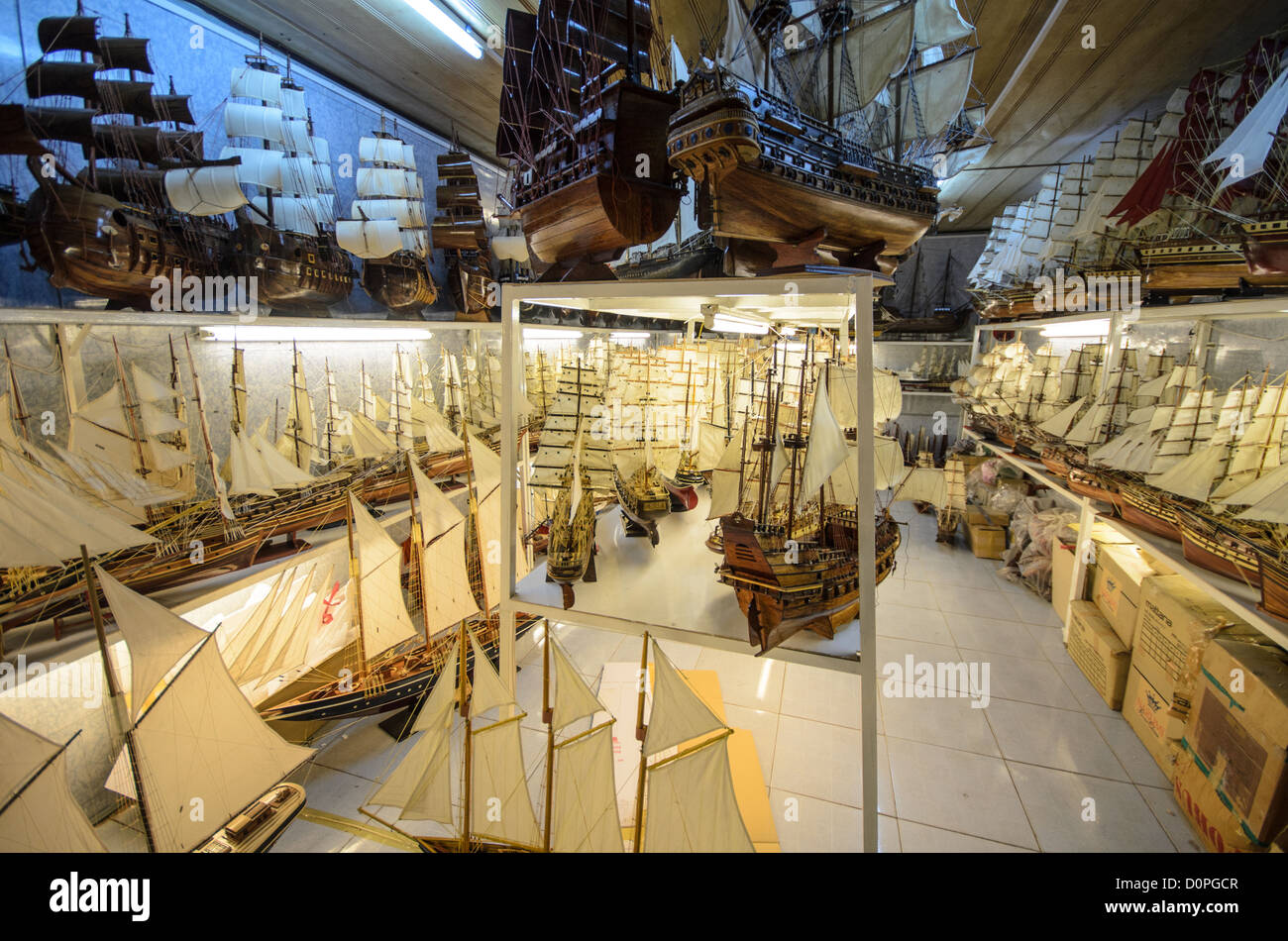 HO CHI MINH CITY, Vietnam — A specialty shop displays dozens of handcrafted model wooden sailing ships, part of a well-established niche craft industry in Vietnam. These detailed replicas are produced primarily in family-run workshops in southern provinces like Bình Dương and Đồng Nai, drawing on Vietnam's traditional woodworking and shipbuilding heritage. The models serve both the tourism market and export trade, appealing to international visitors seeking distinctive Vietnamese souvenirs and maritime enthusiasts worldwide. In Vietnamese and broader Asian cultures, ship imagery is often assoc Stock Photo