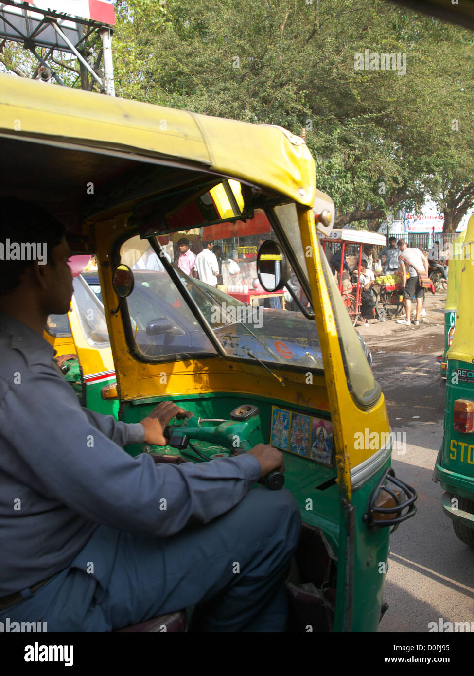 auto rickshaw or Tuk Tuk being driven through the crowded streets of New Delhi, India Stock Photo