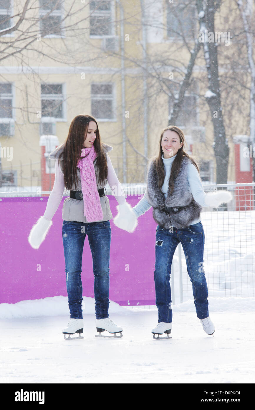 Women iceskating holding hands Stock Photo Alamy