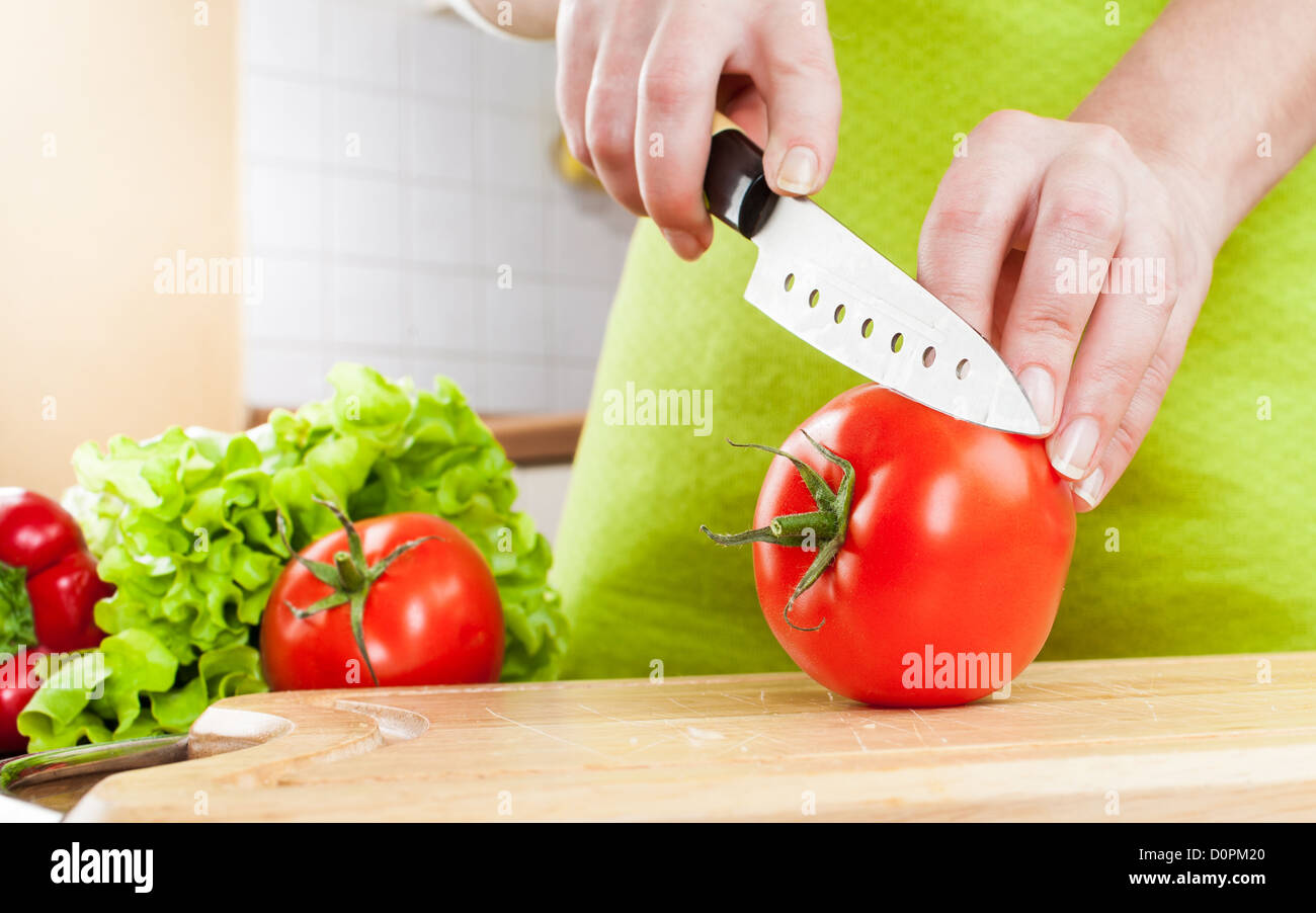 Woman's hands cutting tomato Stock Photo