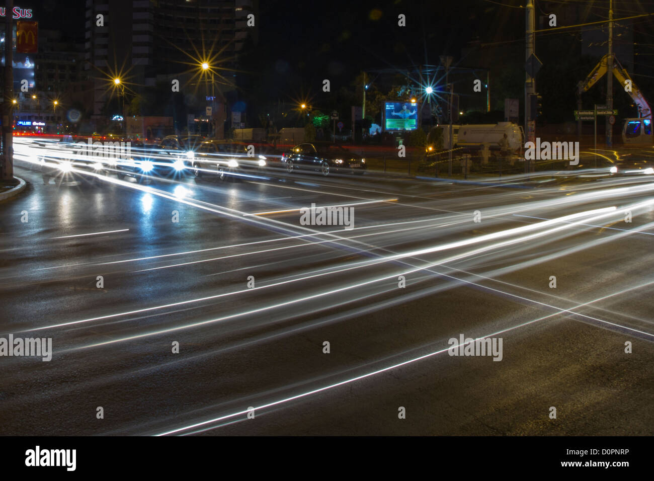 Cars passing by in a crossroad by night Stock Photo
