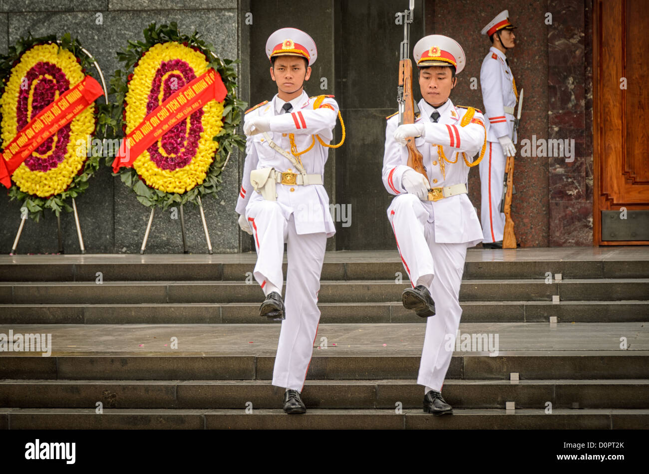 Hanoi Vietnam Two Soldiers Goose Step Their Way From The Entrance Of The Ho Chi Minh Mausoleum At The End Of The Changing Of The Guard Ceremony A Large Memorial In