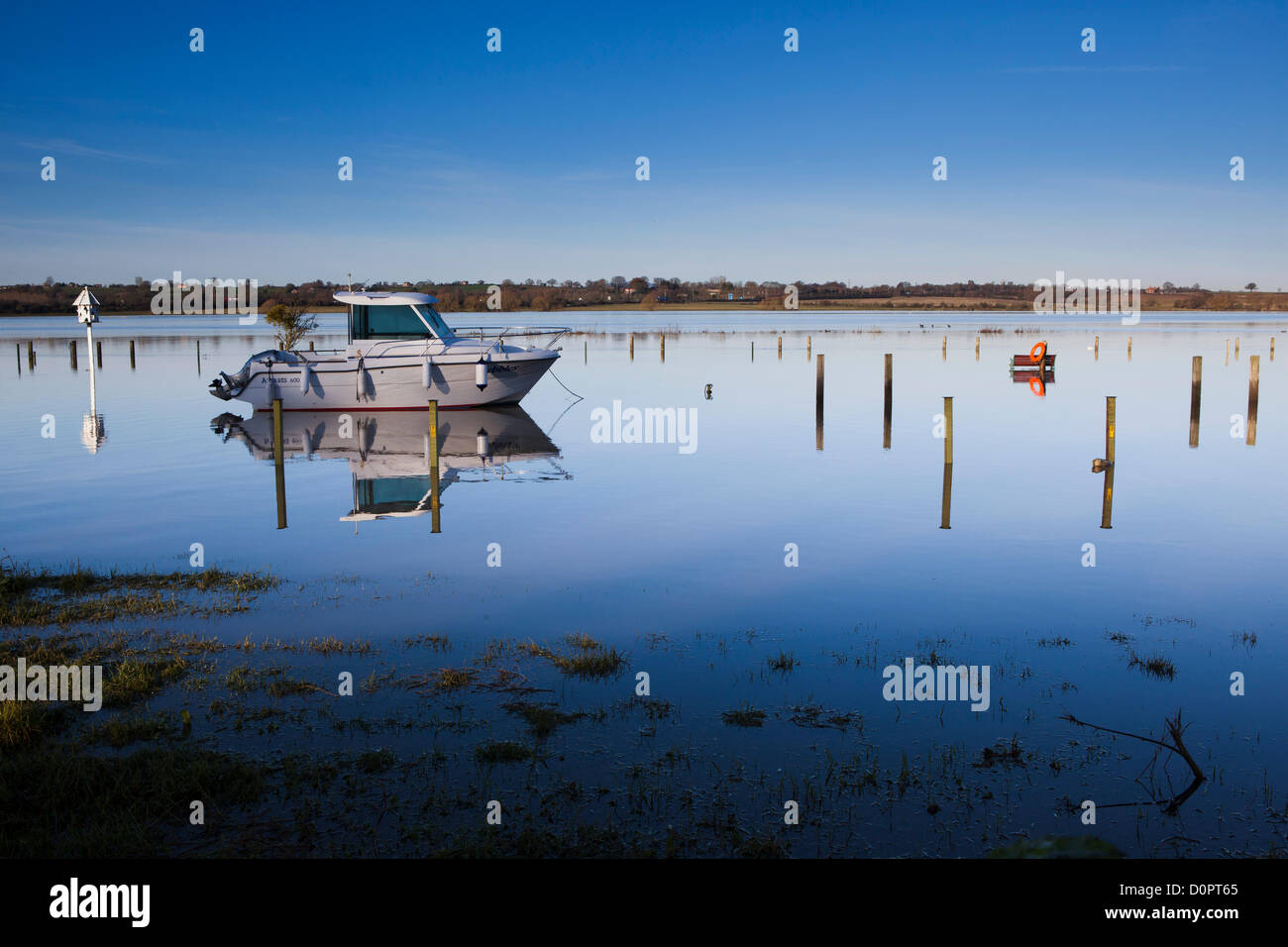 Motor boat with dovecoatd, park bench and life ring submerged in water