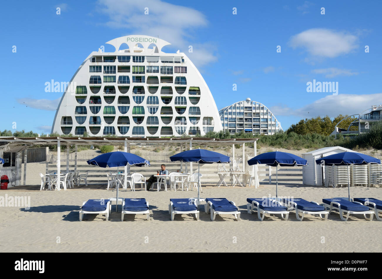 Modern Poseidon (1981) Apartment Building by Gilles Balladur and Beach, Sunloungers & Parasols at Resort Town of La Grande-Motte Hérault France Stock Photo